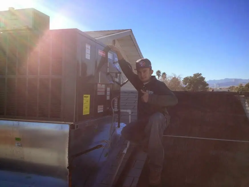 HVAC technician performing AC Tune-Up on a rooftop unit in Vail